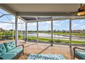 Screened-in patio featuring comfortable seating and panoramic views of the serene lake at 1920 Iglesia St, The Villages, FL 32159