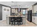 Modern kitchen with granite countertops, stainless steel appliances, a center island with seating, and a stylish backsplash at 2330 Nuthatch St, St Cloud, FL 34771