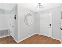 Bright entryway features wood floors, a round mirror and neutral wall paint at 2336 Martins Run, Tavares, FL 32778