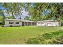 Sprawling ranch home with an oversized lawn, long porch, attached guest home, and three-car garage at 30342 Vitex Ave, Eustis, FL 32736