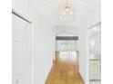 Inviting hallway featuring gleaming wood floors, a decorative light fixture, and open view to living area at 32701 Timberwood, Leesburg, FL 34748