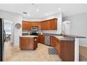 Well-lit kitchen with stainless steel appliances, ample cabinet space, and a convenient island, perfect for cooking at 33316 Irongate Dr, Leesburg, FL 34748