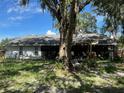 Backyard featuring a screened-in patio and mature trees providing shade at 35219 Haines Creek Rd, Leesburg, FL 34788