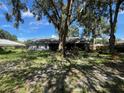 Backyard featuring a screened-in patio and mature trees providing shade at 35219 Haines Creek Rd, Leesburg, FL 34788