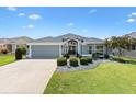 Beautiful home exterior featuring manicured landscaping, neutral paint and elegant architectural details during the day at 3566 Gentle Ter, The Villages, FL 32163