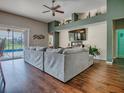 Spacious living room with hardwood floors, custom shelving and a large sectional sofa at 359 Blue Branch St, Eustis, FL 32736