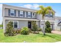 Beautifully landscaped two-story home, featuring blue shutters, green lawn and palm tree at 391 Cheeota Ct, Minneola, FL 34715