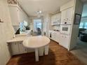 Well-lit kitchen with ample cabinet space, wood flooring, and a breakfast nook at 424 Hawthorne Blvd, Leesburg, FL 34748
