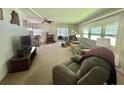 Spacious living room with large windows, comfortable seating, and views into the dining area at 424 Hawthorne Blvd, Leesburg, FL 34748