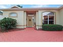 Inviting front entrance with brick pathway, meticulously maintained landscaping, and decorative accents at 5008 Sawgrass Lake Cir, Leesburg, FL 34748