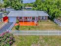 Charming single-story home featuring a brick facade, white picket fence, and a vibrant, welcoming front porch at 564 Lancaster Ave, Orange City, FL 32763