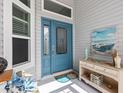 Inviting front entryway with a blue front door, decorative windows, and coordinated decor at 5746 Botner Dr, The Villages, FL 32163