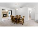 Dining room showcasing a wood dining table, adjoining fireplace, and views to a sun-filled living space at 5825 Lake Emma Ct, Groveland, FL 34736