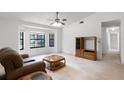 Bright living room featuring a bay window, vaulted ceilings, carpet flooring, and a neutral color palette at 5825 Lake Emma Ct, Groveland, FL 34736