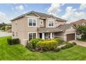 Attractive two-story home with a well-kept lawn and lush green shrubs around the property's foundation at 752 Sandy Bar Dr, Winter Garden, FL 34787