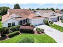 Inviting single-story home with an attached garage and lush landscaping at 8960 Se 178Th Muirfield Pl, The Villages, FL 32162