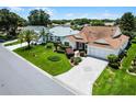 Beautiful house with a manicured lawn, palm tree, and brick-paved driveway at 8960 Se 178Th Muirfield Pl, The Villages, FL 32162