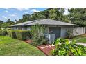 View of home's exterior showing the attached garage, manicured lawn, and neatly trimmed hedges at 902 Lakeview Dr, Eustis, FL 32726