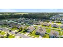 A neighborhood aerial view shows a community featuring well-maintained homes and green lawns at 9785 Pepper Tree Trl, Wildwood, FL 34785