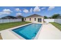 Backyard view showcasing the refreshing pool with pristine white concrete and fence at 9785 Pepper Tree Trl, Wildwood, FL 34785