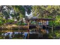 Dock view on a waterfront home, with lush greenery, wood dock and room for boats at 4219 Magnolia Ave, Leesburg, FL 34748