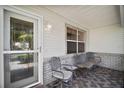 Cozy front porch with seating area, decorative brick accents, and a welcoming entrance door at 1007 Diego Ct, The Villages, FL 32159