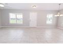 Open living area with tiled floors, neutral walls, and large windows, offering plenty of natural light at 10128 County Road 229, Oxford, FL 34484