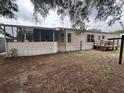 View of the back of a single Gathering home featuring a screened in patio and wooden deck at 10905 Se 127Th Ln, Belleview, FL 34420