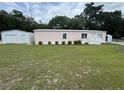 Single Gathering home featuring a detached garage and manicured landscaping at 10905 Se 127Th Ln, Belleview, FL 34420