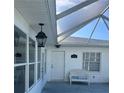 Inviting front porch with bench seating, elegant lighting, and a view of the house number at 1105 Hazelnut Dr, Leesburg, FL 34748