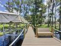 Waterfront dock features seating and access to boat lift, perfect for enjoying the serene lake views at 11401 Cypress Dr, Clermont, FL 34711