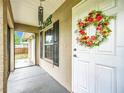 Welcoming front entryway featuring a decorative wreath, a screened entry, and view of the home's interior at 12181 Se 87Th Ct, Belleview, FL 34420