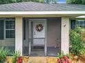Close up of the front screened door with wreath, showcasing the entrance to the house at 12181 Se 87Th Ct, Belleview, FL 34420