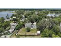 Aerial shot showcases the home's location amidst mature trees and tranquil lakes in a peaceful neighborhood at 126 E Beach St, Groveland, FL 34736