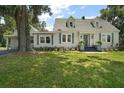 Charming two-story home with dormer windows and inviting front entrance, surrounded by a lush green lawn at 126 E Beach St, Groveland, FL 34736