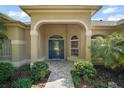 Elegant home entrance with a beautiful blue door and manicured landscaping at 13 Hickory Head Hammock, The Villages, FL 32159