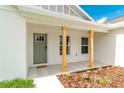 Inviting front porch featuring wood columns and a green front door with a 'hello' doormat at 13334 Sw 107Th St, Dunnellon, FL 34432