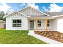 Close up of a cozy front porch with decorative wooden posts and a green front door at 13334 Sw 107Th St, Dunnellon, FL 34432