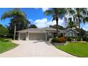 Charming single-story home with a three-car garage, beautiful landscaping, and mature palm trees in a suburban neighborhood at 1335 Eureka Mill Run, The Villages, FL 32162