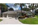 Charming single-story home with a three-car garage, beautiful landscaping, and mature palm trees in a suburban neighborhood at 1335 Eureka Mill Run, The Villages, FL 32162
