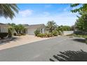 Charming home showcasing lush landscaping, a well-maintained lawn, and inviting curb appeal, complete with a two-car garage at 1664 Vinewood Ave, The Villages, FL 32162