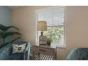 Comfortable sitting area featuring a side table, lamp, chairs, and a large window allowing natural light into the space at 1664 Vinewood Ave, The Villages, FL 32162