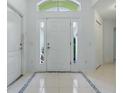 Bright foyer with tile flooring, decorative door accents, and ample natural light at 17037 Se 76Th Creekside Cir, The Villages, FL 32162