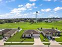 Aerial view of a neighborhood with a single-Gathering home featuring a large lawn and proximity to green spaces at 1940 Piedmont Ct, Mascotte, FL 34753