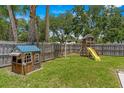 Backyard featuring a playhouse, a swing, and a slide, set in a grassy area at 204 Lori Ct, Umatilla, FL 32784