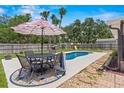 Inviting backyard with a sparkling pool, patio furniture, and lush greenery, perfect for entertaining at 204 Lori Ct, Umatilla, FL 32784