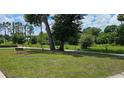 A quiet community park featuring mature trees, a swing, and a walking path at 235 Rockmoore Ct, Deland, FL 32720