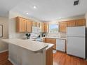 Functional kitchen featuring wood cabinets, a breakfast bar, and modern appliances, perfect for casual dining and meal preparation at 2369 Five Forks Trl, The Villages, FL 32162