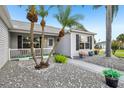Charming front porch adorned with tropical plants and a tranquil, gravel yard at 2455 Five Forks Trl, The Villages, FL 32162