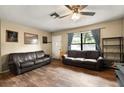 Inviting living room with two sofas, wood flooring, and a large window with curtains, offering a cozy atmosphere at 25824 Shawnee St, Sorrento, FL 32776